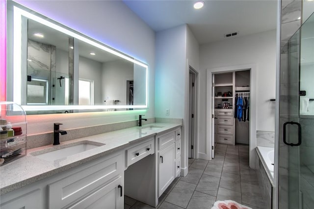 6730 Effat Dr, Corpus Christi, TX 78414 - full bath featuring double vanity, a stall shower, a walk in closet, a garden tub, and tile patterned floors