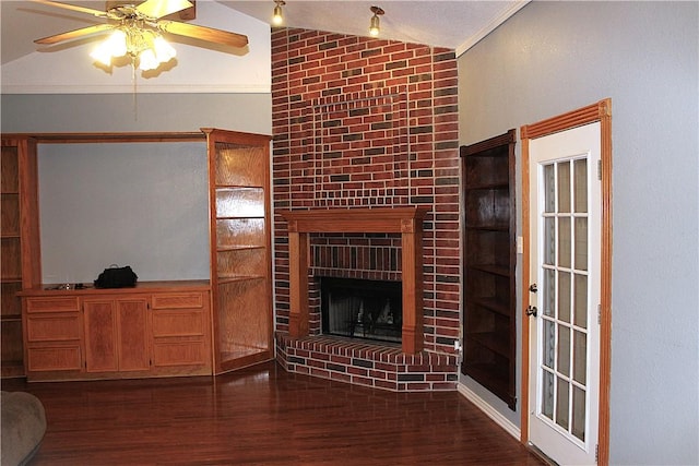 living area featuring vaulted ceiling, a brick fireplace, dark wood finished floors, and a ceiling fan