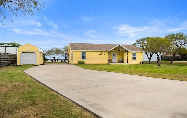 single story home featuring a garage, an outdoor structure, and a front yard