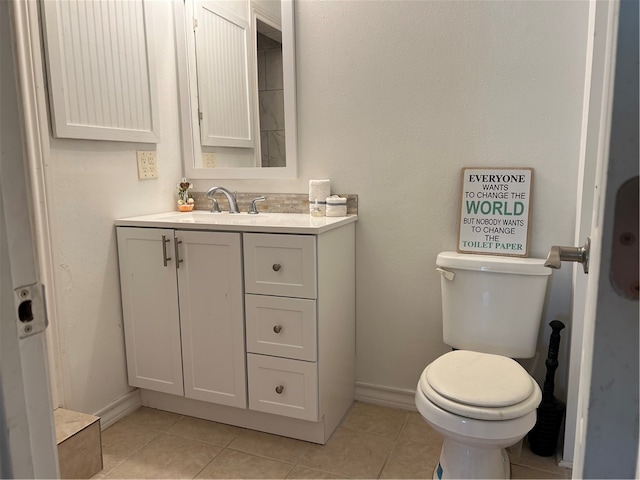 bathroom with tile patterned flooring, vanity, and toilet