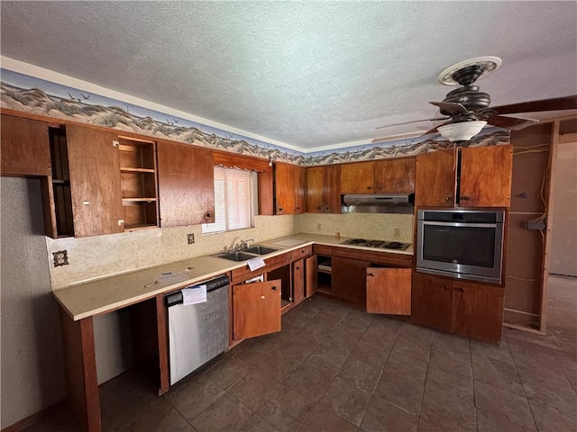 kitchen with ceiling fan, stainless steel appliances, a textured ceiling, and sink