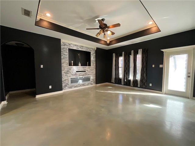 unfurnished living room featuring a tray ceiling, a fireplace, visible vents, and finished concrete floors