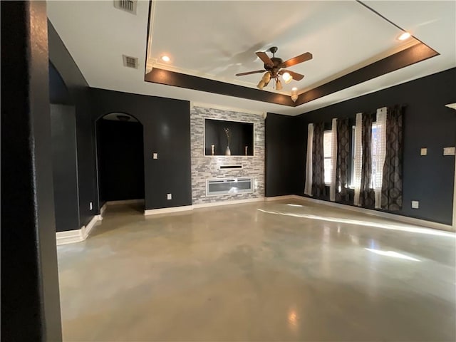 interior space with visible vents, baseboards, concrete floors, a fireplace, and a raised ceiling