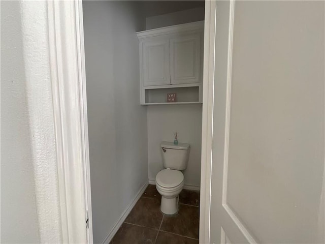 bathroom with tile patterned floors, toilet, and baseboards