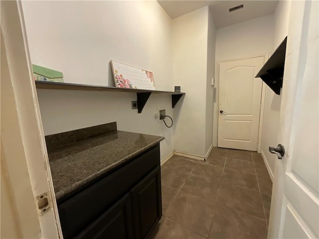 washroom featuring baseboards, laundry area, electric dryer hookup, washer hookup, and dark tile patterned floors