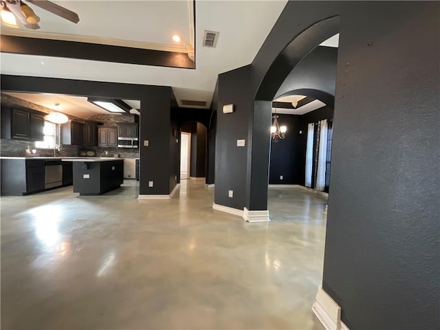 unfurnished living room featuring arched walkways, visible vents, concrete flooring, and baseboards