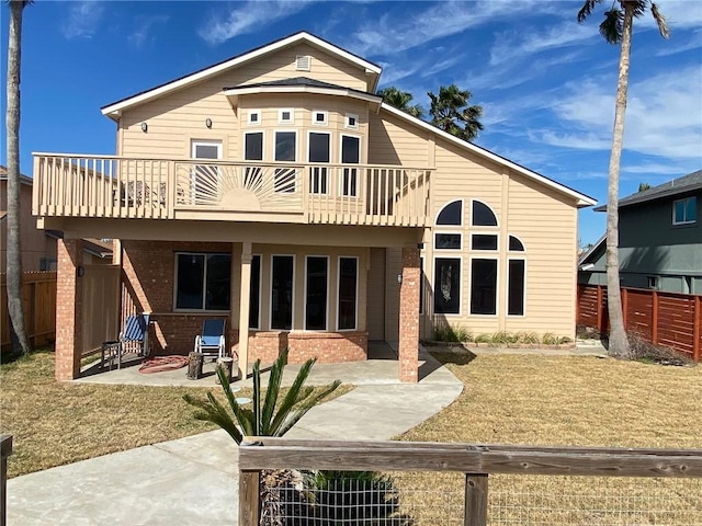 rear view of house with a patio, a balcony, and a fire pit