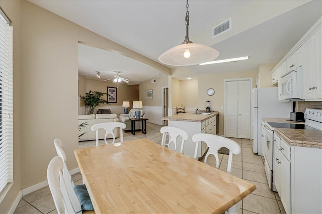 dining space featuring sink, light tile patterned floors, and ceiling fan