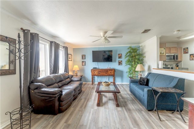 living room with ornamental molding, light hardwood / wood-style floors, and ceiling fan