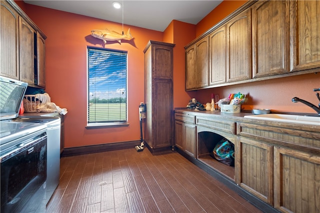 laundry room featuring separate washer and dryer, cabinets, sink, and dark hardwood / wood-style floors