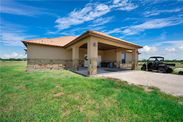 view of property exterior with a lawn and a patio area