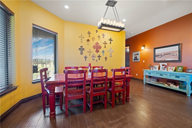 dining area featuring dark wood-type flooring and an inviting chandelier