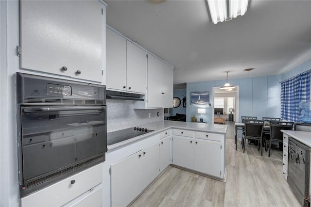 1038 Herndon St, Corpus Christi, TX 78411 - kitchen featuring black appliances, under cabinet range hood, light wood-style flooring, and white cabinetry