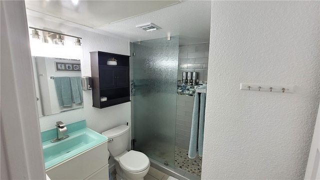 bathroom featuring tile patterned flooring, a textured ceiling, vanity, a shower with shower door, and toilet