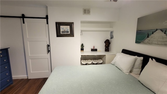 bedroom with dark wood-type flooring and a barn door