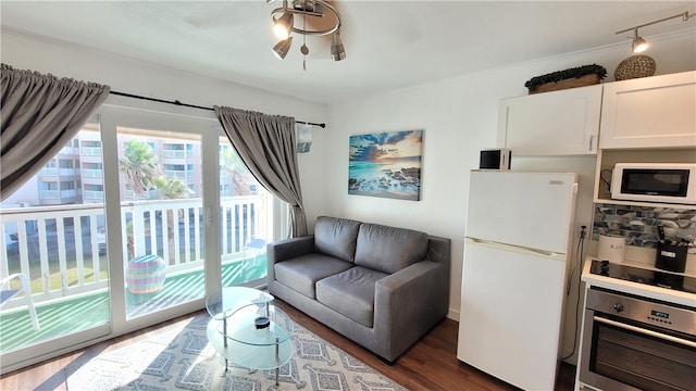 living room with dark wood-type flooring and ceiling fan