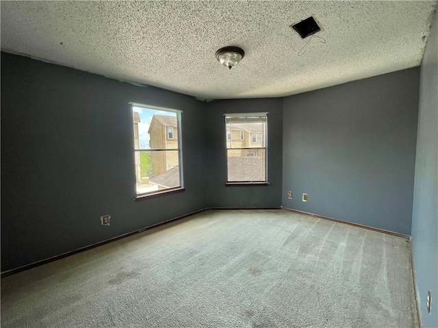 carpeted spare room featuring a textured ceiling