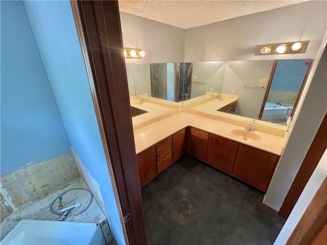 bathroom with vanity, a textured ceiling, and a bath