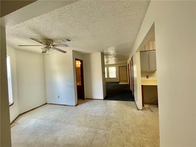 unfurnished room with a textured ceiling and ceiling fan