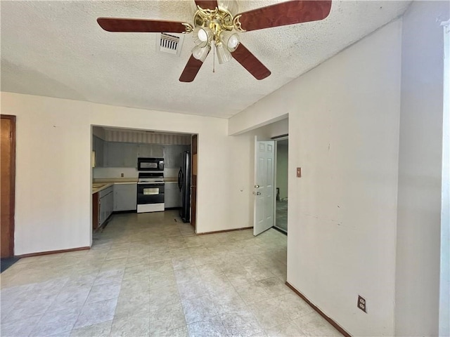 unfurnished living room with ceiling fan and a textured ceiling