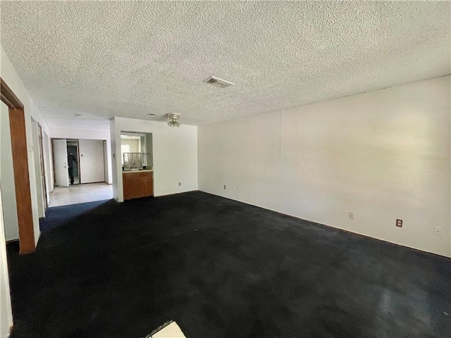 unfurnished room with carpet flooring and a textured ceiling