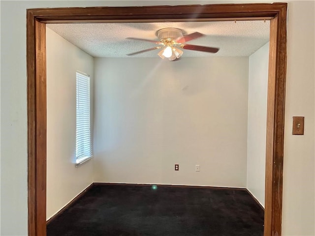 unfurnished room with ceiling fan, a textured ceiling, plenty of natural light, and carpet