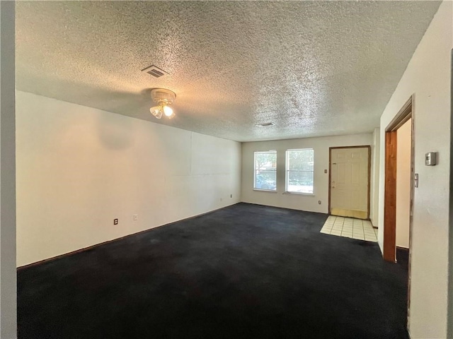 spare room featuring a textured ceiling and carpet floors