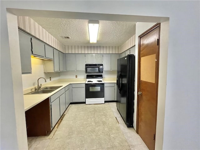 kitchen with black appliances, gray cabinetry, a textured ceiling, light tile patterned floors, and sink