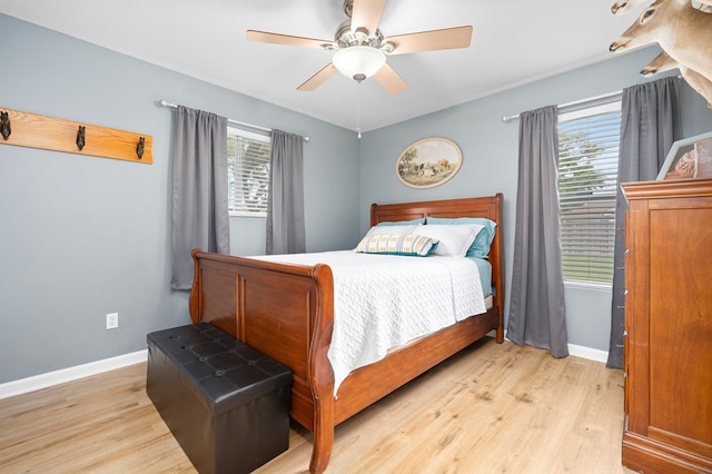 bedroom featuring baseboards, ceiling fan, and light wood-style flooring