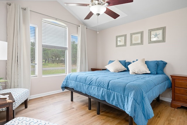 bedroom with light wood-type flooring, baseboards, ceiling fan, and vaulted ceiling