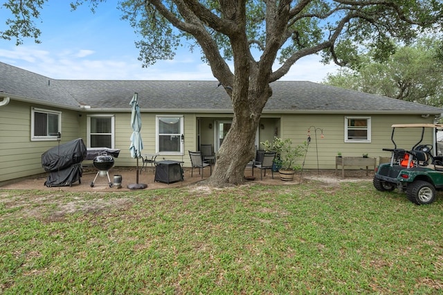 back of property with a lawn and a patio area