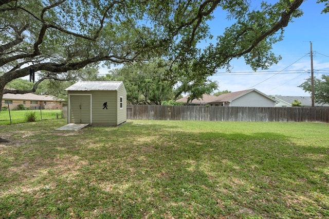 view of yard with an outbuilding, a fenced backyard, and a shed
