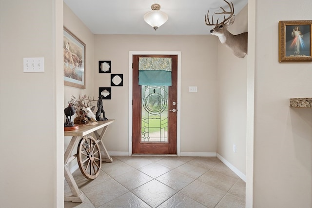 tiled entryway featuring baseboards
