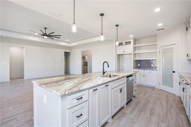 kitchen with ceiling fan, dishwasher, sink, a center island with sink, and white cabinets