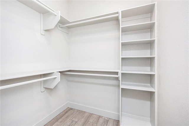 walk in closet with light wood-type flooring