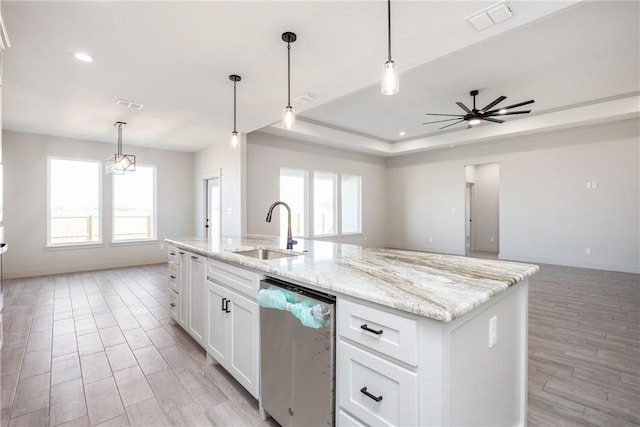 kitchen with ceiling fan, white cabinetry, dishwasher, sink, and an island with sink