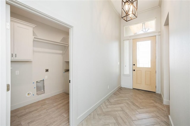 laundry area featuring hookup for an electric dryer, hookup for a gas dryer, crown molding, light parquet floors, and a chandelier