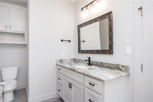 bathroom with vanity, hardwood / wood-style flooring, and toilet