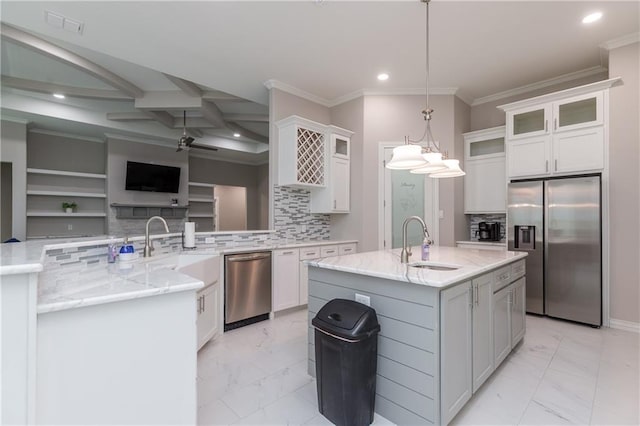 kitchen with sink, white cabinetry, hanging light fixtures, stainless steel appliances, and a center island with sink