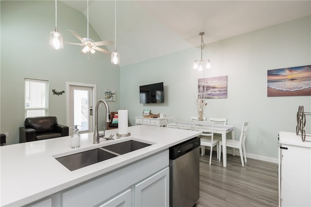 kitchen with pendant lighting, white cabinets, sink, stainless steel dishwasher, and wood-type flooring