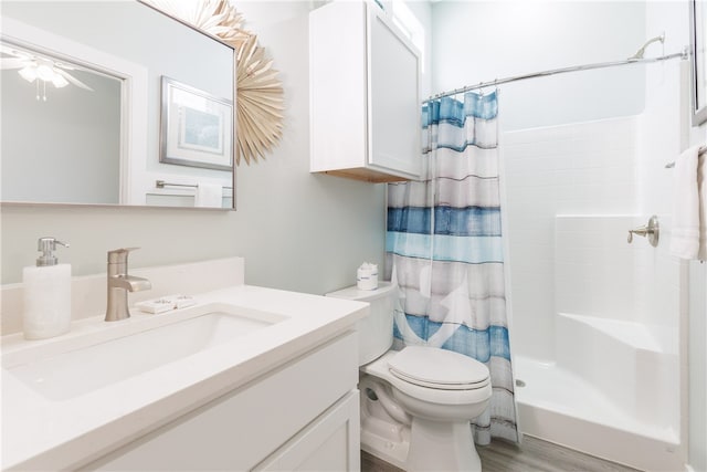 bathroom featuring toilet, vanity, wood-type flooring, and walk in shower