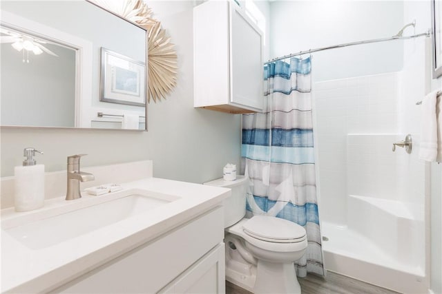 14921 Pirates Cove Dr, Corpus Christi, TX 78418 - bathroom with toilet, a shower with shower curtain, vanity, wood finished floors, and ceiling fan