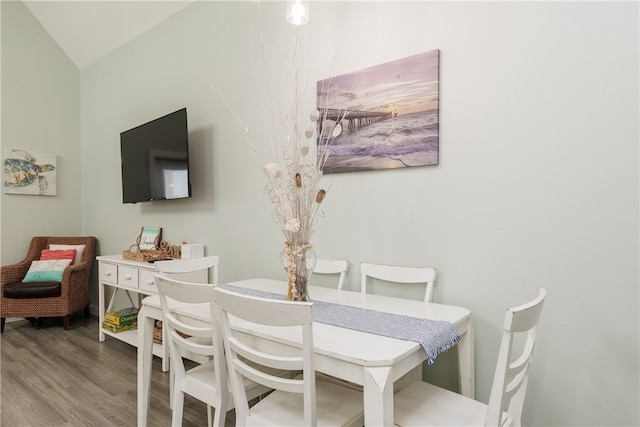 dining room with wood-type flooring and lofted ceiling