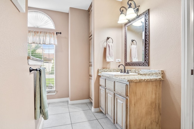 bathroom with vanity, tile patterned flooring, and a healthy amount of sunlight