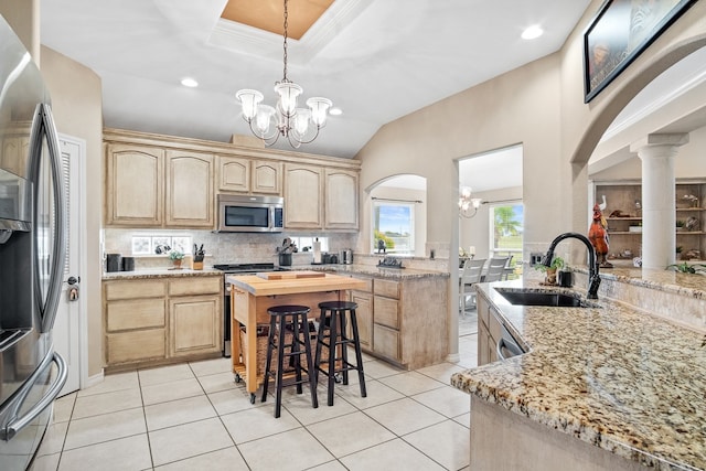 kitchen with sink, appliances with stainless steel finishes, light brown cabinets, light tile patterned floors, and an inviting chandelier