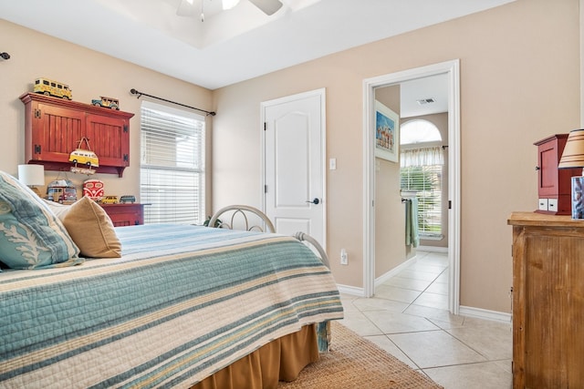 bedroom featuring multiple windows, light tile patterned floors, and ceiling fan