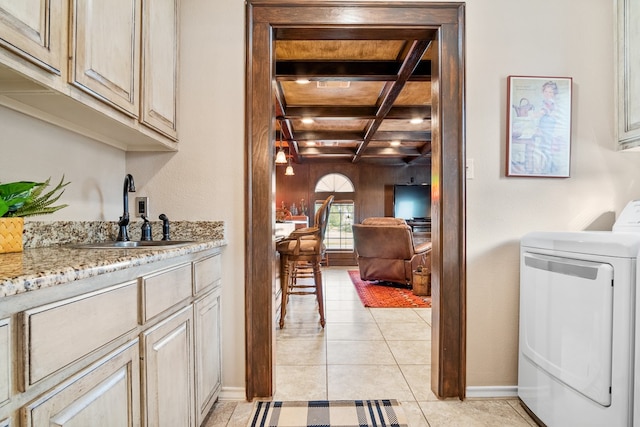 laundry area featuring cabinets, washer / dryer, sink, and light tile patterned flooring