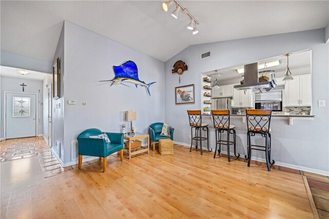 15641 Three Fathoms Bank Dr, Corpus Christi, TX 78418 - sitting room with track lighting, vaulted ceiling, baseboards, and light wood-type flooring