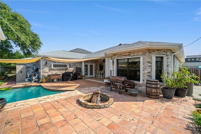 15641 Three Fathoms Bank Dr, Corpus Christi, TX 78418 - back of house with french doors, an outdoor fire pit, a patio, and stone siding