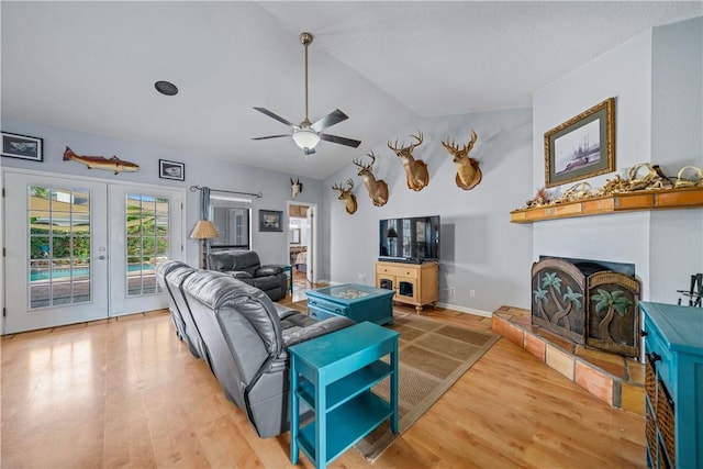 15641 Three Fathoms Bank Dr, Corpus Christi, TX 78418 - living area featuring french doors, vaulted ceiling, light wood-style flooring, a ceiling fan, and a fireplace with raised hearth
